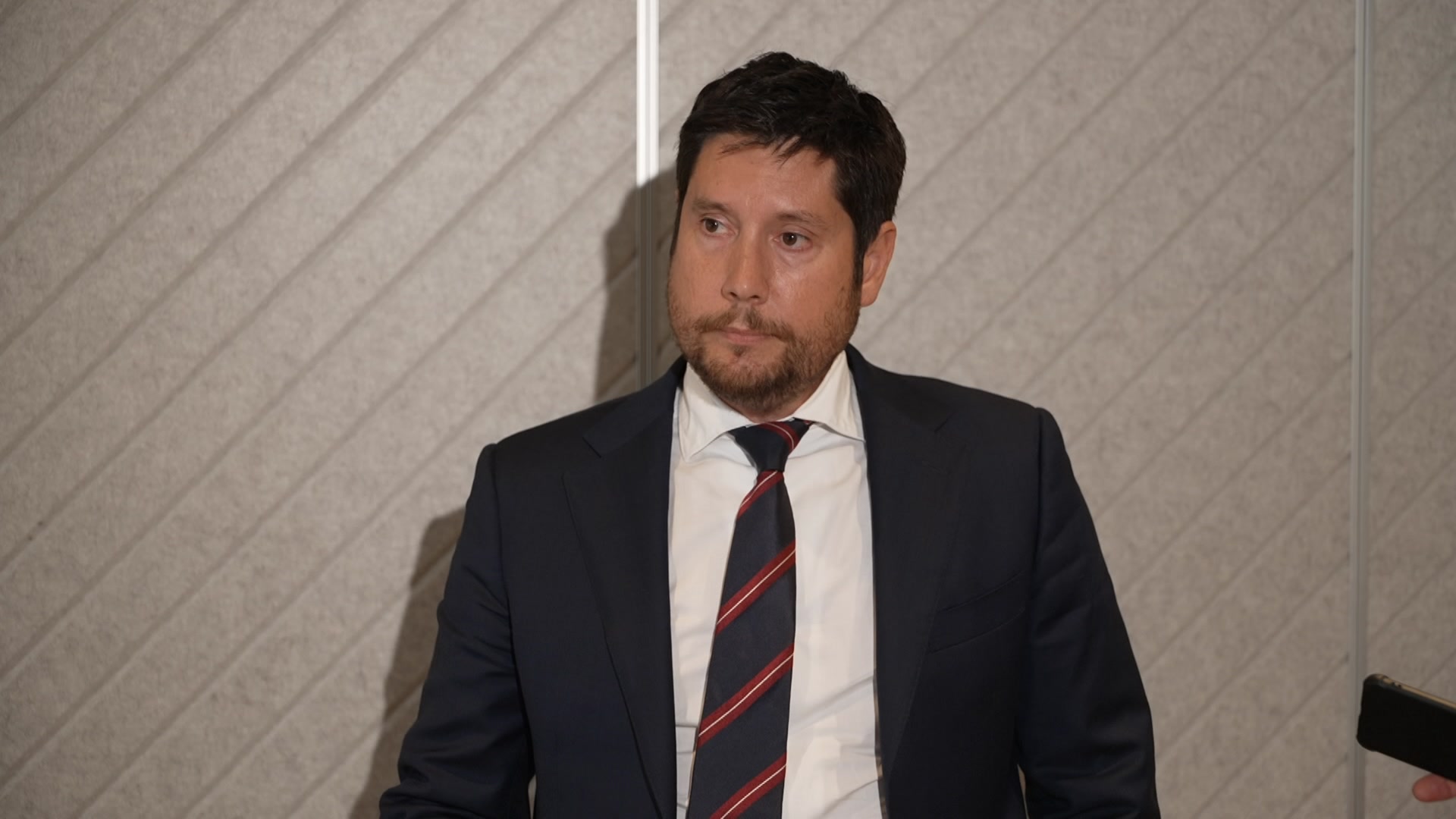 A man in a suit looking at the camera 