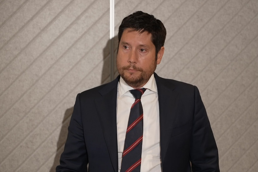 A man in a suit looking at the camera  A man in a suit looking at the camera