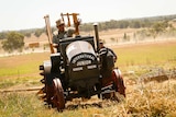 Tony Pailthorpe waves at eh camera as he drives one of his vintage tractors