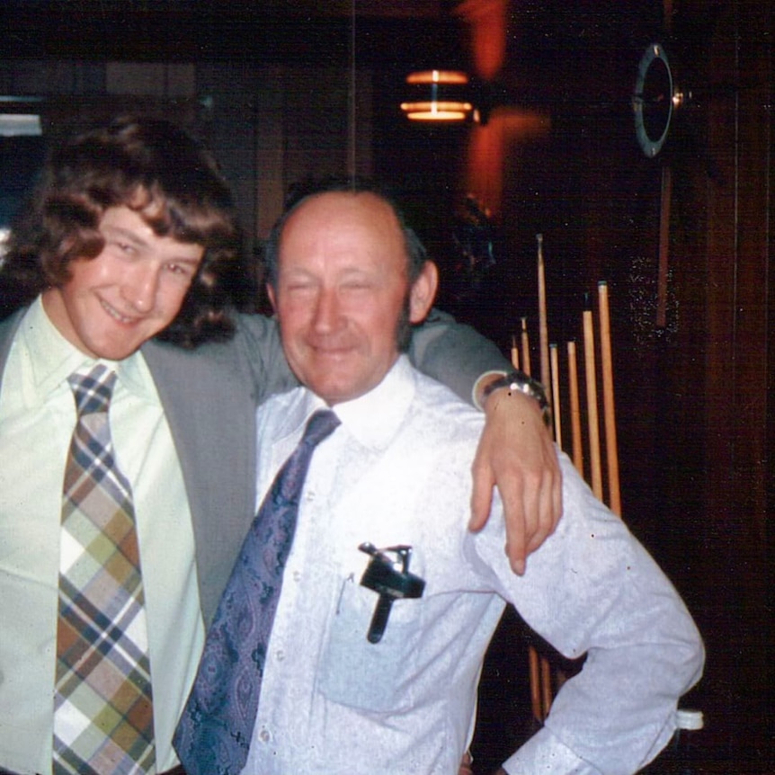 A young man with shoulder length hair next to a middle aged man with a receding hair line.