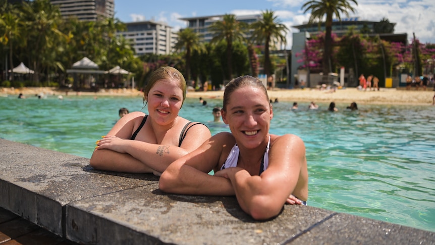 Two female swimmers resting on the edge of South Bank pool, Brisbane