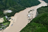 This aerial view shows the Kuma River flooded with heavy rain with buildings nearby flooded