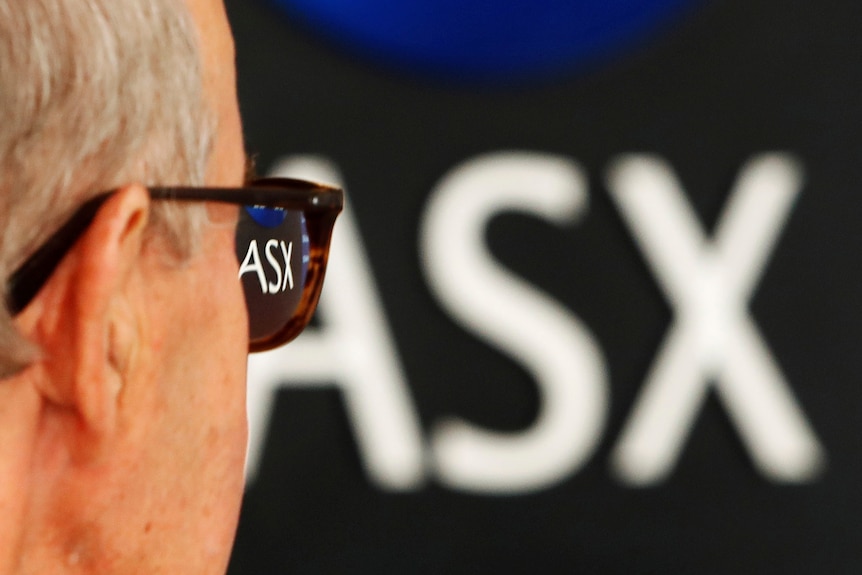 The back of a man's head looking at a ASX sign