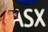 The back of a man's head looking at a ASX sign