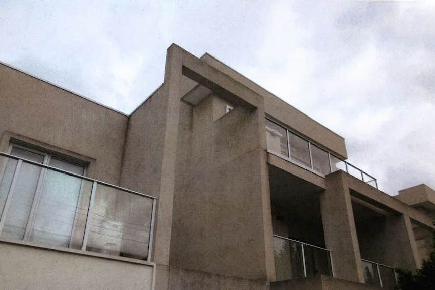 Mould covers the outside walls on a concrete apartment building.