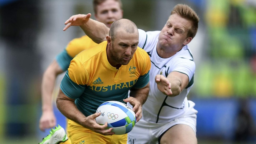 A man runs with a ball under his arm.