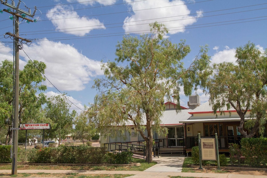 The outside of an RSL in a country town surrounded by gum trees on a sunny day. Two signs say "Winton Club".