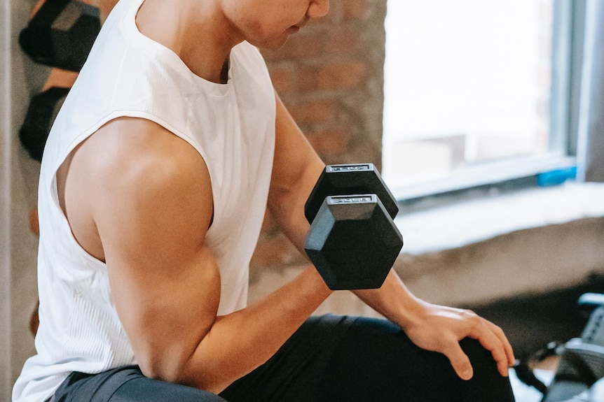 A man doing a bicep curl in a gym