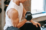A man doing a bicep curl in a gym