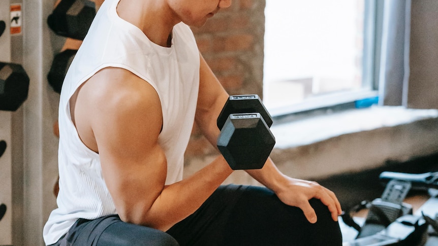 A man doing a bicep curl in a gym