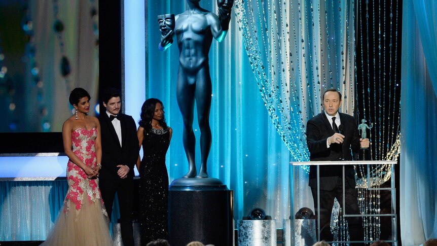Actor Kevin Spacey stand on stage to accept his SAG Award.