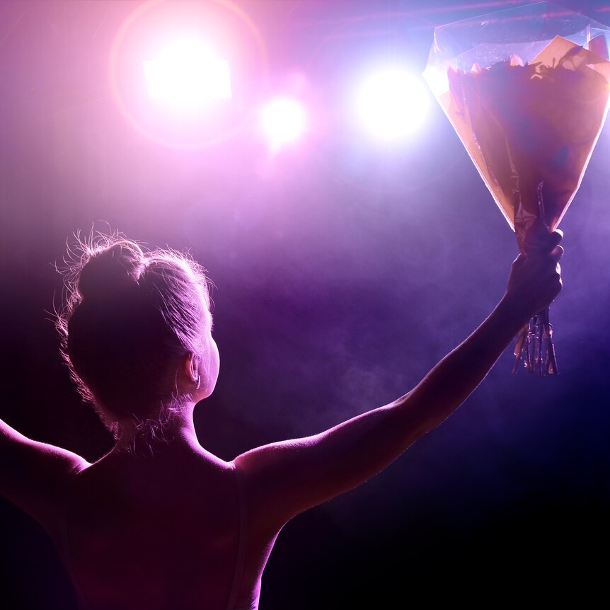 A young woman artist receives a bouquet of flowers on stage