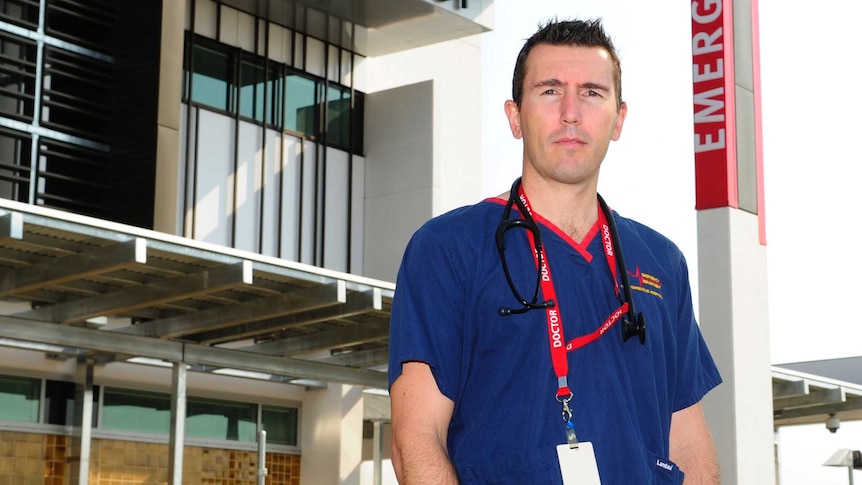 Doctor in scrubs standing outside emergency department