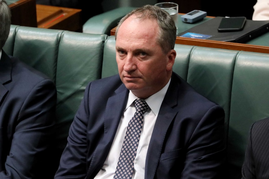 Barnaby Joyce sits in the House of Representatives with a tired expression on his face. He frowns, with bags beneath his eyes.
