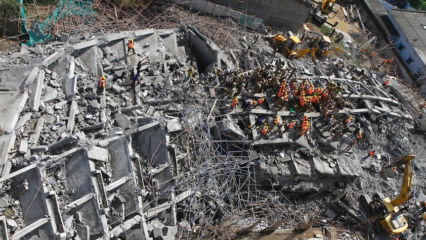Rescue workers search for survivors under the rubble of a collapsed building in Chennai, India