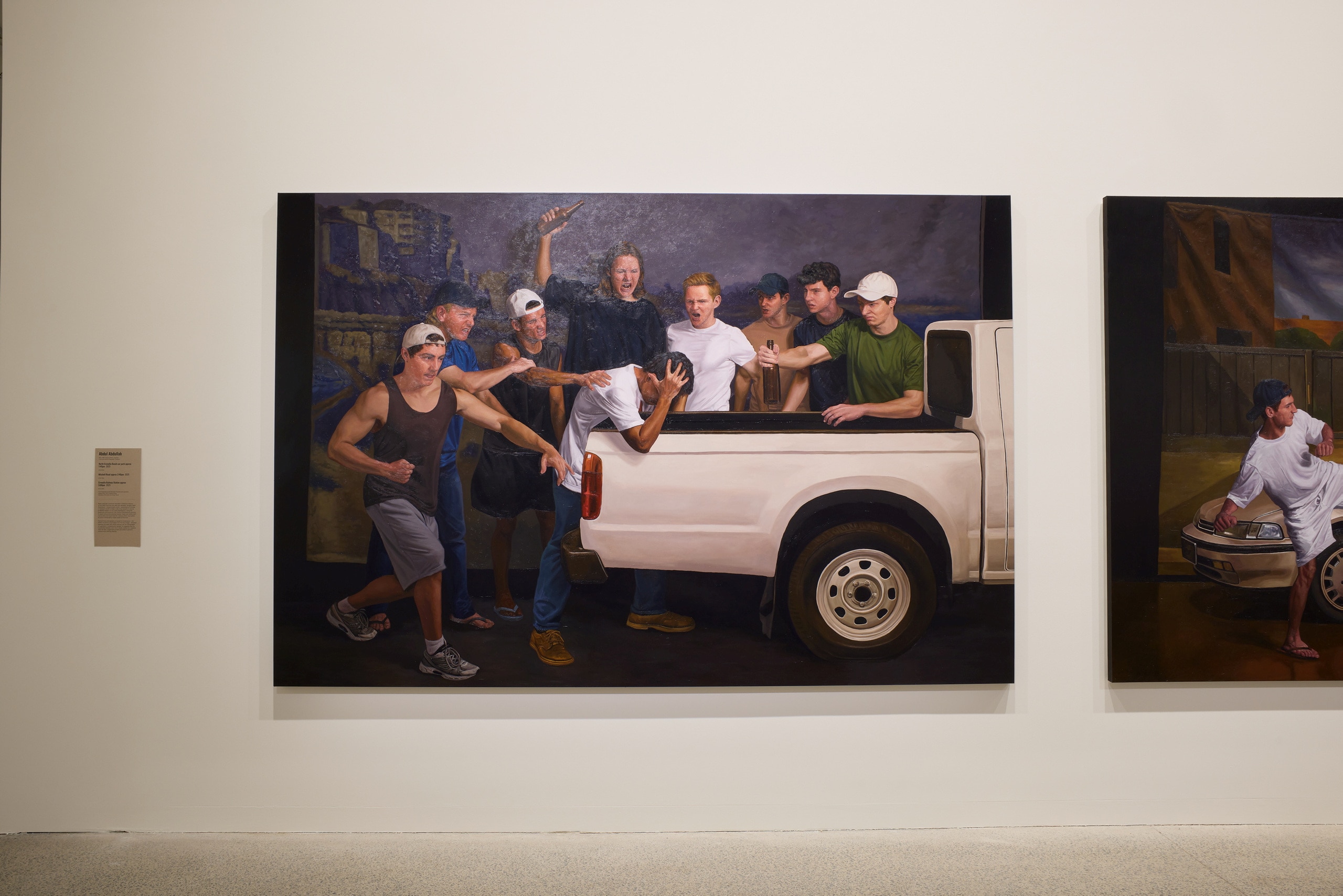 A painting depicting a group of angry white men attacking a dark-skinned man next to a white ute.