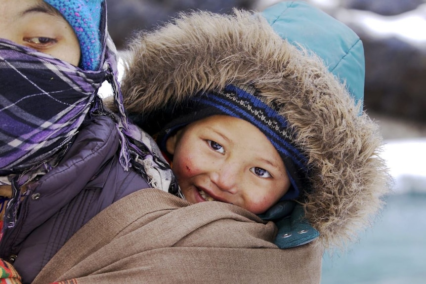 A child is being carried on the back.