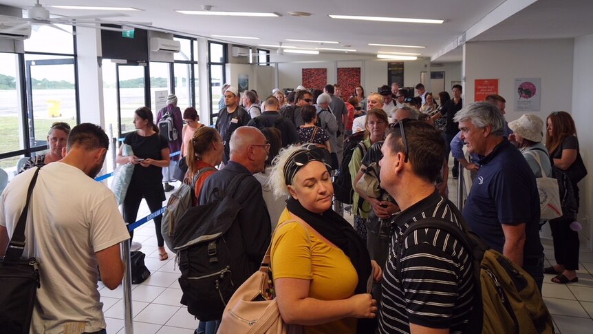 A group of people standing in line at Christmas Island airport.