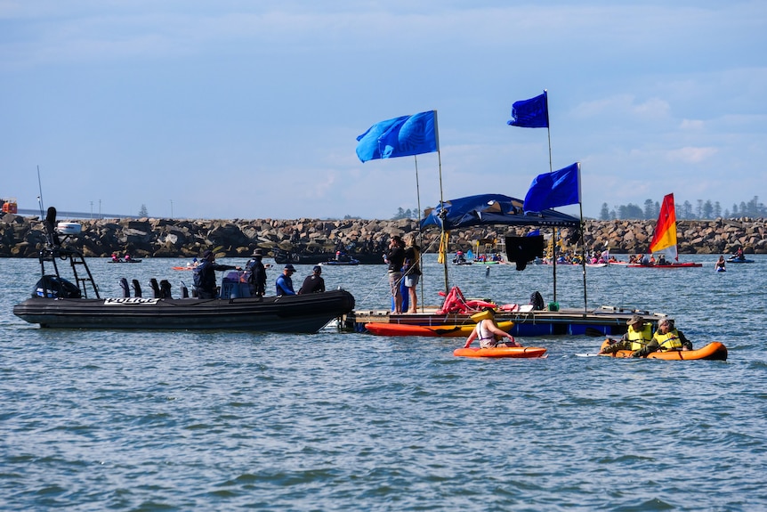 A police boat approaches people in kayaks.