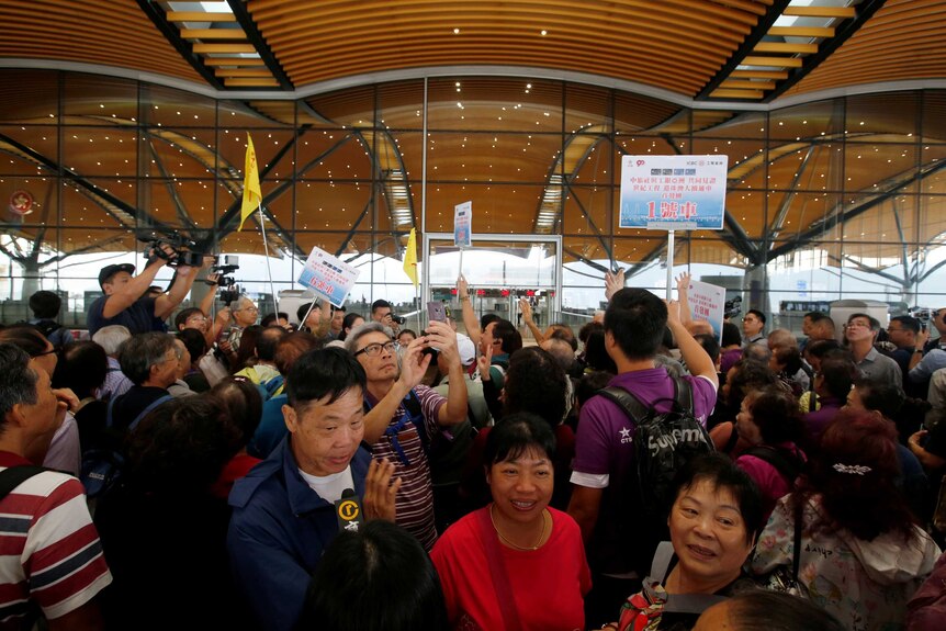 A crowd of Chinese tourist at a bridge terminal.