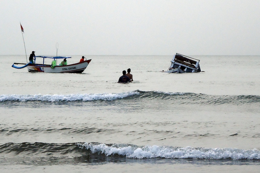 Rescuers approach a capsized asylum seeker boat off  Indonesia's West Java province.