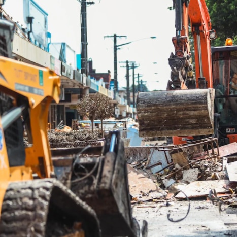 Diggers and other machinery cleans up debris covering Lismore streets.