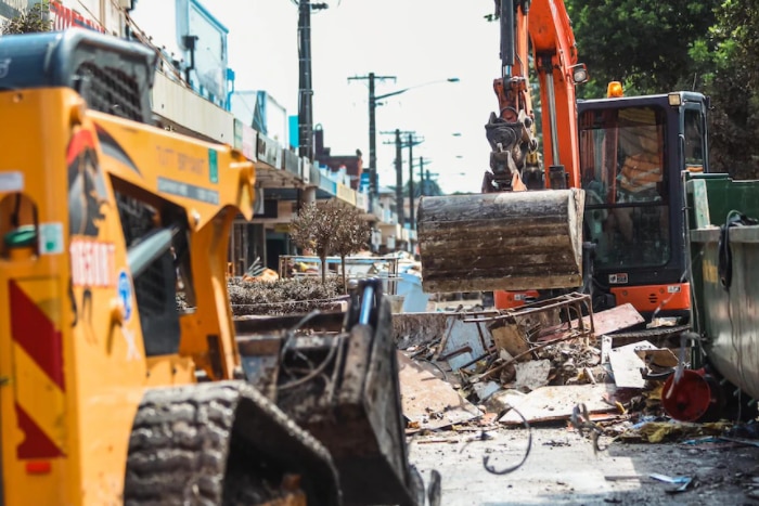 Machinery sorts through rubbish on Lismore streets after record floods.