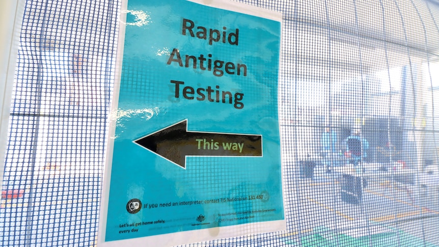 A sign at a building site that says "rapid antigen testing".