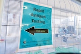A sign at a building site that says "rapid antigen testing".