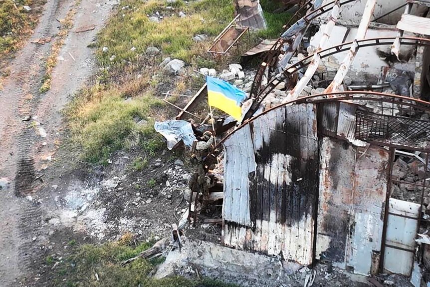 Ukrainian soldiers install the state flag on Snake island, in the Black Sea.
