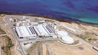 An aerial view of an industrial site next to the ocean.