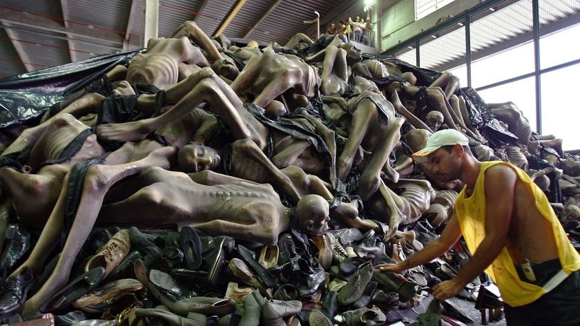 A man works on a carnival float depicting the Holocaust