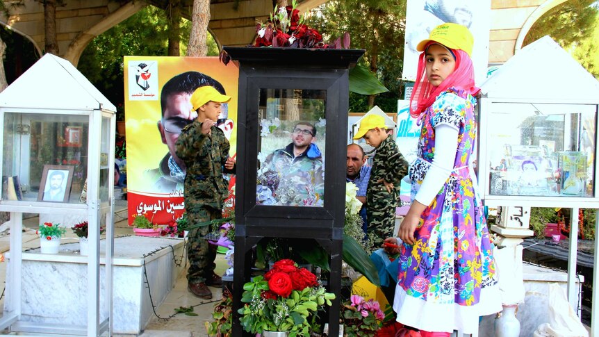 Kids standing near graves of Hezbollah fighters killed in Syria buried beside those killed fighting Israel in south Lebanon.