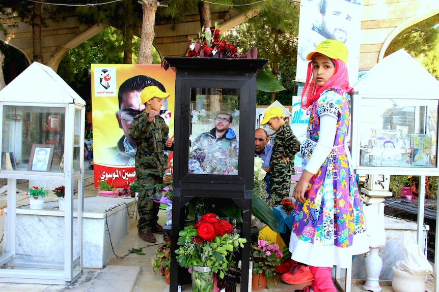 Kids standing near graves of Hezbollah fighters killed in Syria buried beside those killed fighting Israel in south Lebanon.