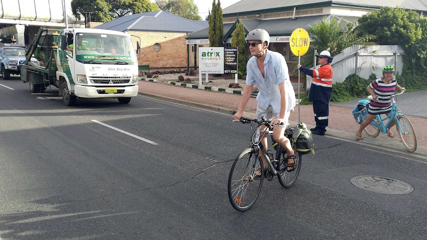 Cyclists are helped across South Road.