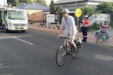 Cyclists are helped across South Road.