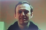 Russian opposition leader Alexei Navalny is seen on a screen via video link from a penal colony.