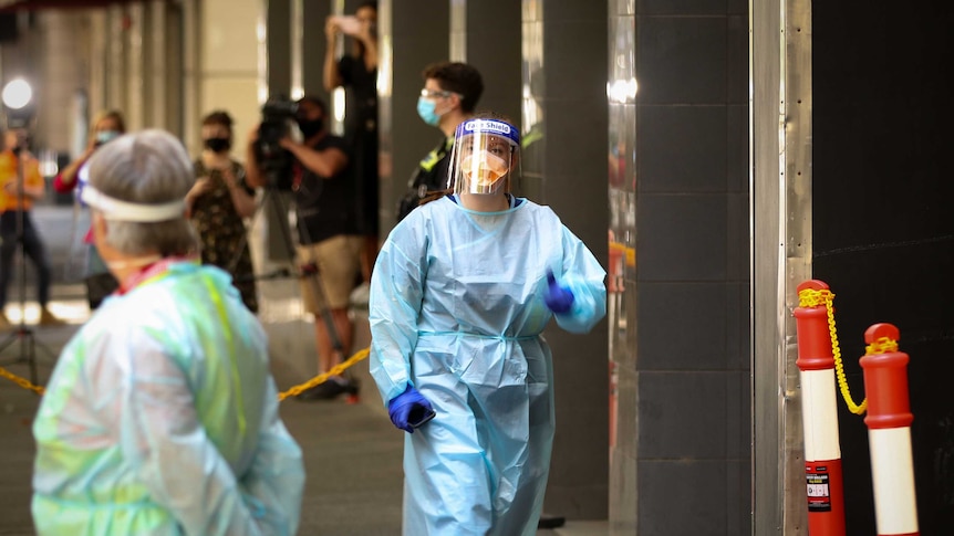 A woman wearing personal protective equipment including a gown, face shield, mask and gloves.