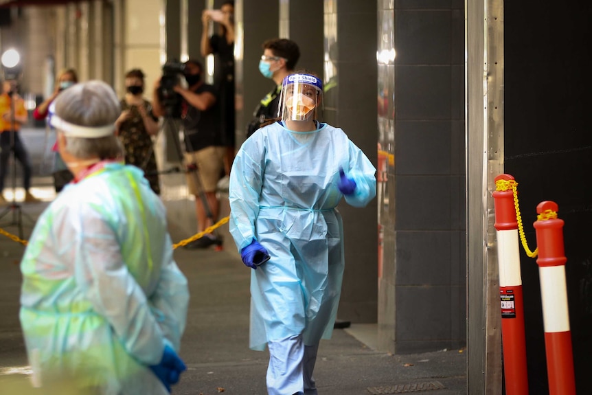 A woman wearing personal protective equipment including a gown, face shield, mask and gloves.