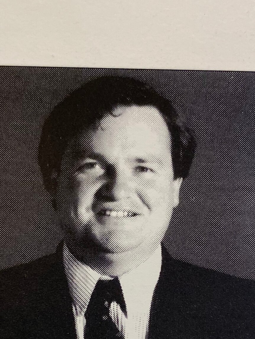 A head shot from a football club annual report of the club president in a suit and tie.