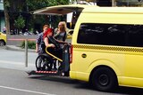 Samantha Connor getting into a wheelchair accessible taxi van.