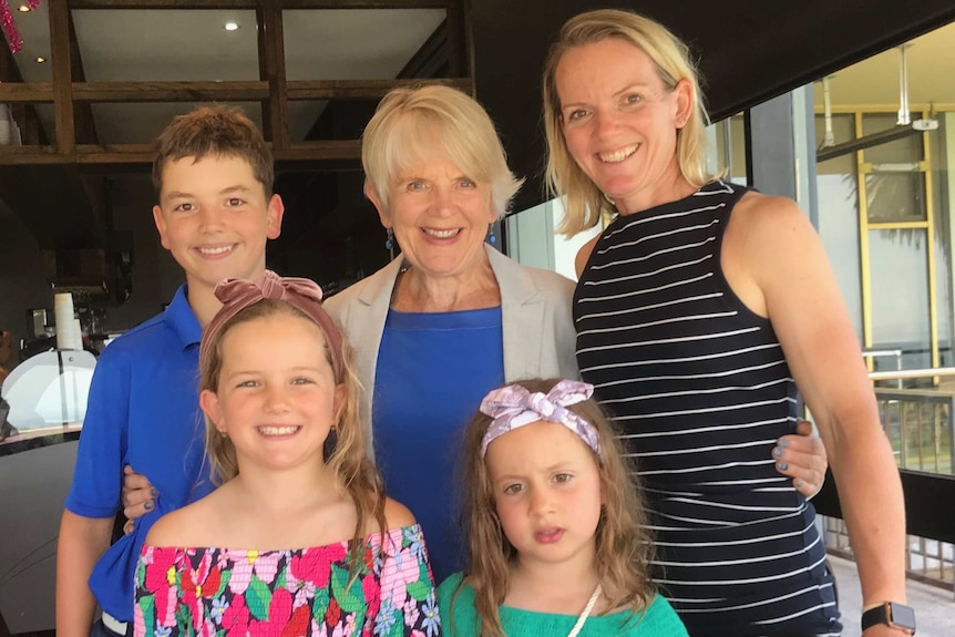June Alexander with her three grandchildren and her daughter at a restaurant.