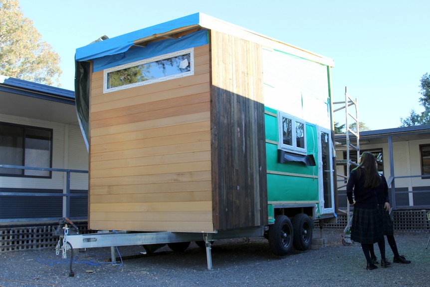 A tiny house standing on a trailer.