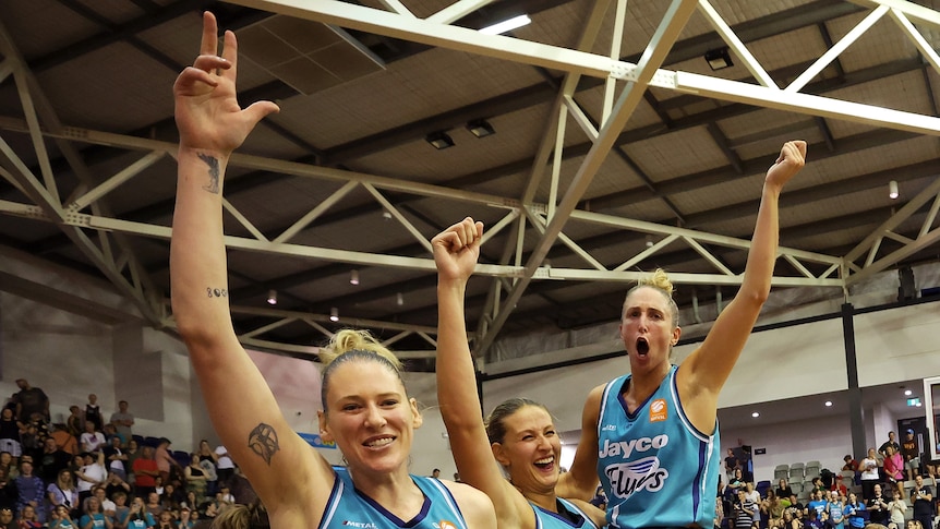 Carley Ernst, Rebecca Cole and Lauren Jackson hold up their hands