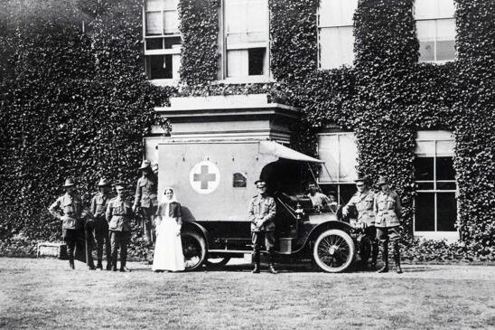 Nurses, soldiers and an ambulance stand in front of Harefield Manor
