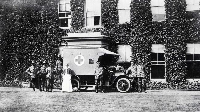 Nurses, soldiers and an ambulance stand in front of Harefield Manor