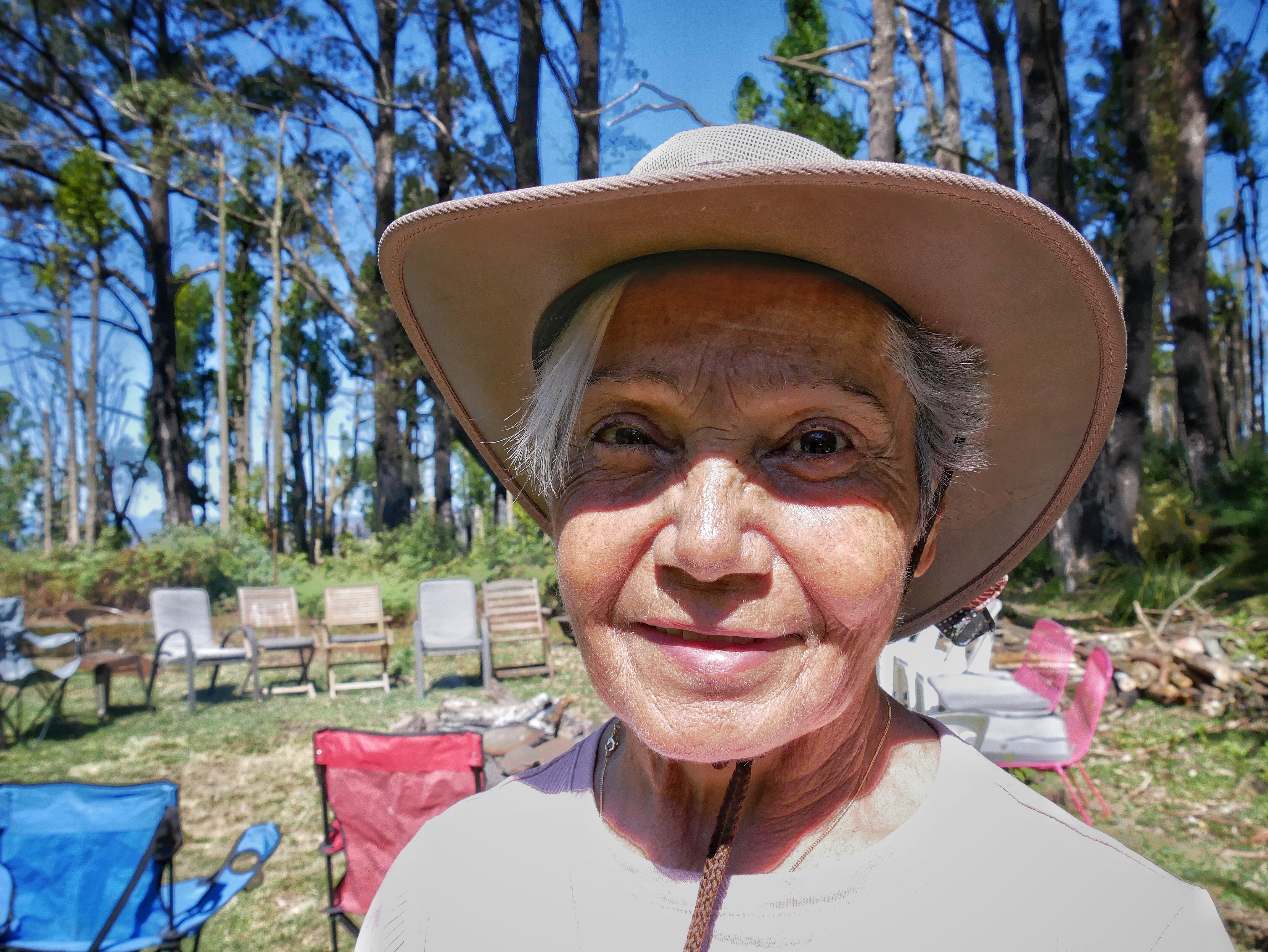 A woman standing in the bush and smiling.