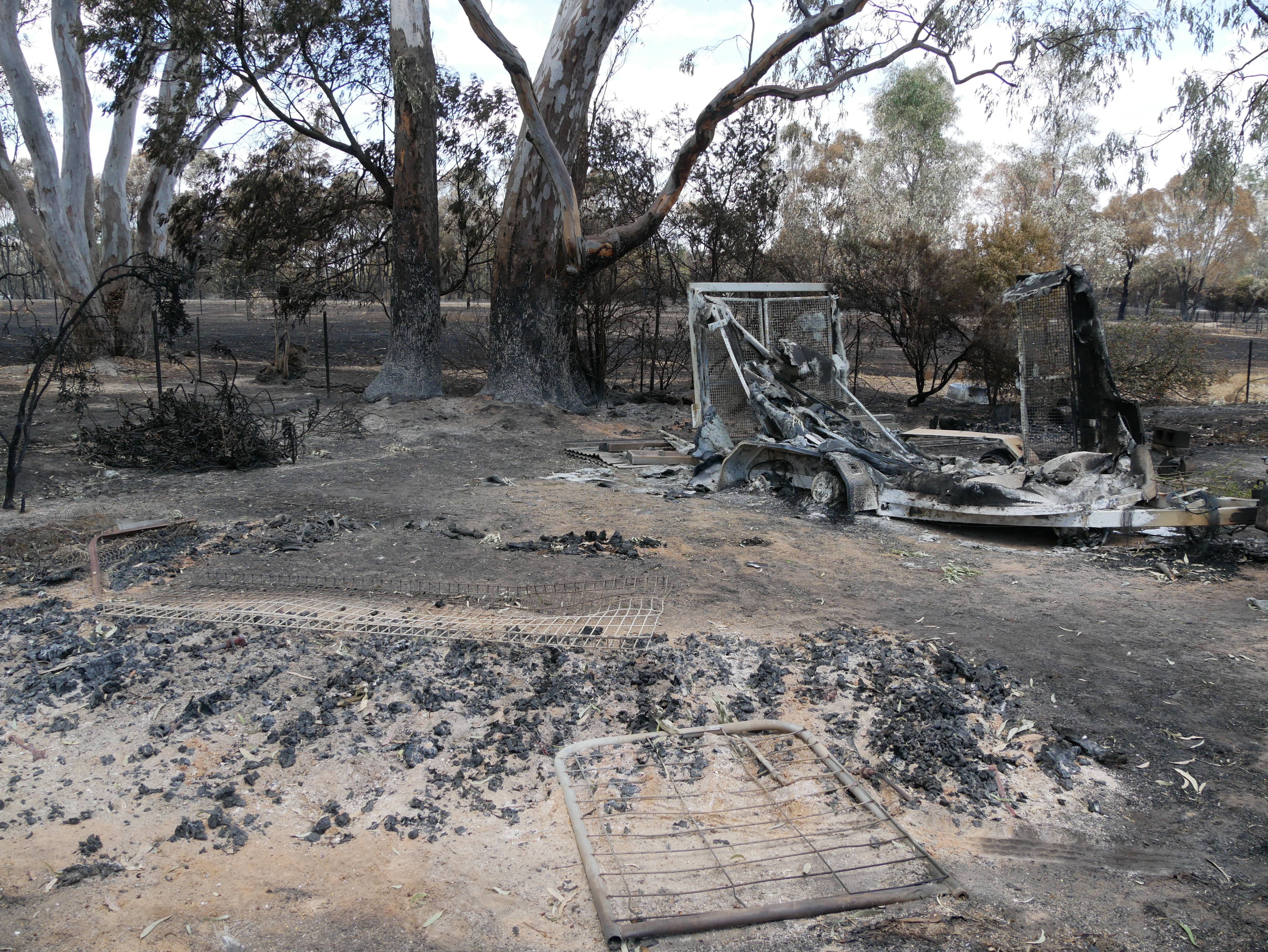 Una propiedad quemada con edificios en ruinas tras un incendio forestal