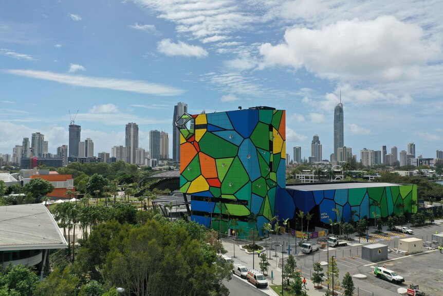 Bright multi-coloured building in the mid-ground with highrises of Surfers Paradise in the background