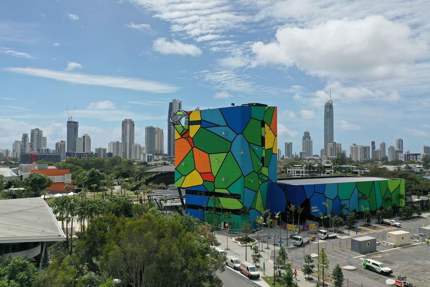 Bright multi-coloured building in the mid-ground with the high-rises of Surfers Paradise in the background.